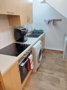 a small kitchen with a sink and a washing machine at 8 Firth Square in Kirkwall