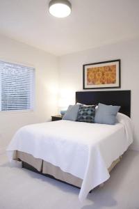 a white bedroom with a large white bed and a window at Apt 5 Miami Designer Apartment in the Upper East-Side in Miami