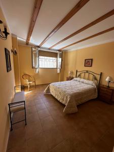 1 dormitorio con 1 cama, mesa y silla en Apartamentos Cuesta de la Cruz, en Caravaca de la Cruz