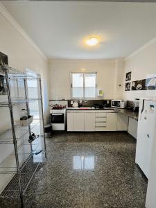 a kitchen with white cabinets and a white refrigerator at LK GRAJAÚ 1 in Belo Horizonte