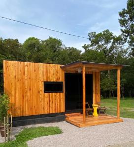 einem Holzschuppen mit einem Tisch und einer Bank in der Unterkunft Cabanas Loft Paraíso in Gramado