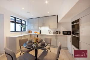 eine Küche und ein Esszimmer mit einem Tisch und Stühlen in der Unterkunft Modern 3 Bedroom Apartment - Wokingham in Wokingham