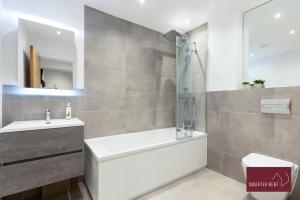La salle de bains est pourvue d'une baignoire, d'un lavabo et d'une douche. dans l'établissement Modern 3 Bedroom Apartment - Wokingham, à Wokingham