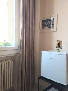 una nevera blanca en una habitación con ventana en Private room and bathroom close to Piazzale Roma in Venice Mestre, en Mestre