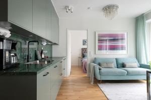 sala de estar con sofá azul en la cocina en Modern elegance i Hagastaden en Estocolmo