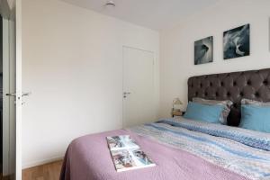 - une chambre avec un lit doté d'un couvre-lit violet dans l'établissement Modern elegance i Hagastaden, à Stockholm