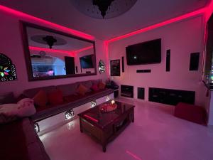 a living room with a couch and red lighting at Riad le pélican in Marrakech