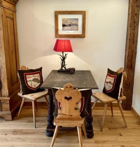 a table with chairs and a lamp on top at Mountain Suites by Belle-Stay in Kitzbühel