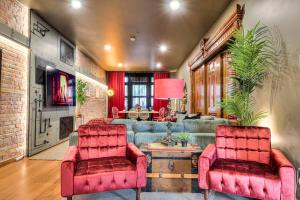 uma sala de estar com um sofá azul e duas cadeiras vermelhas em Location, Comfort, & Convenience - Steam Punk MTL em Montreal