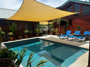 a swimming pool with a yellow umbrella over a house at Pura Vida Cabinita in Uvita