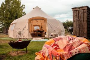 a tent with a bed in front of it at The Follies Glamping in Maidstone