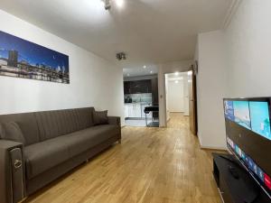 a living room with a couch and a flat screen tv at London 2Bedrooms 2Bathrooms, Balcony, Parking, Lovely South Woodford in London