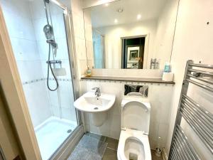 La salle de bains est pourvue de toilettes, d'un lavabo et d'une douche. dans l'établissement Contractors and Relocation Multiple Houses London, à Londres
