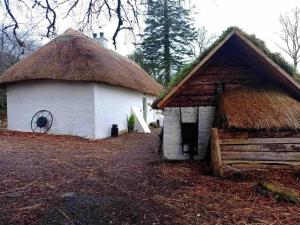 un piccolo edificio bianco con tetto di paglia di Traditional Irish Thatched Cottage a Florencecourt
