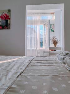 biała sypialnia z łóżkiem i oknem w obiekcie Studio Bobo w Rovinj
