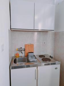 a small kitchen with a sink and a stove at Studio Bobo in Rovinj