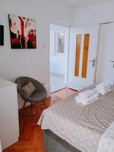 a bedroom with a bed and a chair in it at Studio Bobo in Rovinj