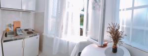 a white kitchen with a sink and a window at Studio Bobo in Rovinj +3 photos