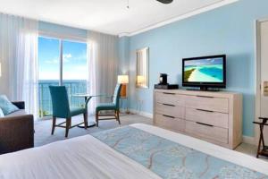 a hotel room with a bedroom with a bed and a television at The Palms, Ocean View Studio Located at Ritz Carlton - Key Biscayne in Miami