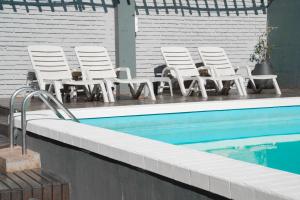 伊瓜蘇港的住宿－ISONDU Suites & Breakfast，一组椅子坐在游泳池旁