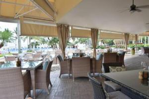 um restaurante com mesas e cadeiras e um pátio em The Palms, Ocean View Studio Located at Ritz Carlton - Key Biscayne em Miami