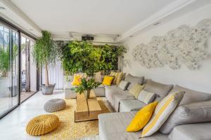 ein Wohnzimmer mit einem grauen Sofa und gelben Kissen in der Unterkunft Large villa with pool in Châtillon - Welkeys in Châtillon