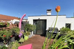 eine Terrasse mit Pflanzen und Blumen auf einem Gebäude in der Unterkunft Large villa with pool in Châtillon - Welkeys in Châtillon