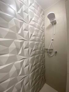 a bathroom with a shower with a geometriciled wall at Apartamento com vista espetacular na Cidade Baixa in Porto Alegre