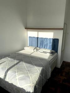 ein Schlafzimmer mit einem Bett mit einem blauen Vorhang in der Unterkunft Apartamento com vista espetacular na Cidade Baixa in Porto Alegre