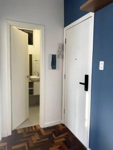 ein Badezimmer mit einer weißen Tür und einem Waschbecken in der Unterkunft Apartamento com vista espetacular na Cidade Baixa in Porto Alegre