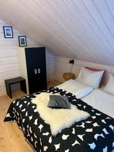 a bedroom with a black and white bed in a attic at Villa LumiHelmi A & B in Äkäslompolo