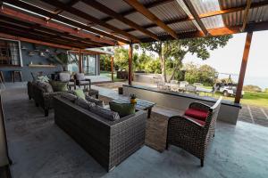 an outdoor patio with couches and a bar at The Forest Dome by Once Upon a Dome @ Misty Mountain Reserve in Stormsriviermond