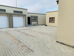 a house with two garage doors and a driveway at TALITHA'S SELF-CATERING ACCOMMODATION in Walvis Bay