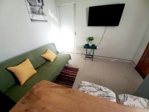 a living room with a green couch and a television at TALITHA'S SELF-CATERING ACCOMMODATION in Walvis Bay