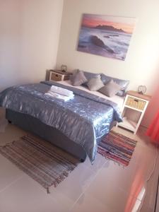 1 dormitorio con 1 cama con una pintura en la pared en TALITHA'S SELF-CATERING ACCOMMODATION, en Walvis Bay