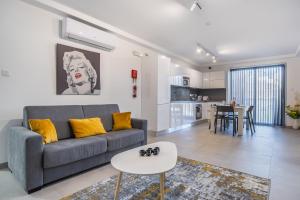 een woonkamer met een bank en een tafel bij Msida Park Residence C5 in Msida