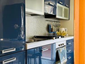 a kitchen with blue cabinets and a sink at Casa Orchidea Altera in Marzamemi