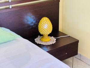 a yellow lamp sitting on a table next to a bed at Casa Orchidea Altera in Marzamemi
