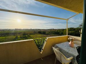 a balcony with a table and a view of a field at Casa Orchidea Altera in Marzamemi