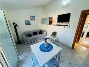 a living room with a table and a couch at Casa Orchidea Altera in Marzamemi