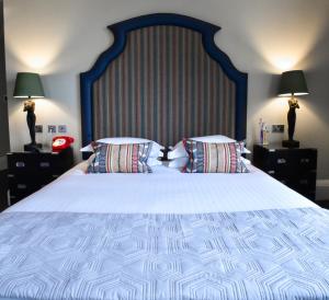 a bedroom with a large bed with two pillows at The Rutland Hotel & Apartments in Edinburgh