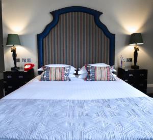 een slaapkamer met een groot bed met 2 kussens bij The Rutland Hotel & Apartments in Edinburgh