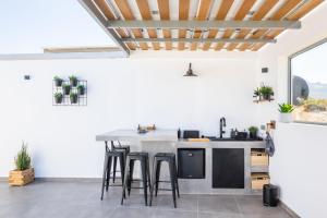 an open kitchen with a counter and stools at Villa Pleiades in Karpathos