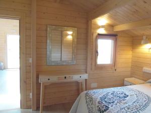 um quarto com uma cama num chalé de madeira em El Naval de la Parra I em Sejas de Sanabria