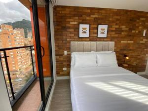 een bed in een kamer met een groot raam bij Apartamento academia 1201 in Bogota