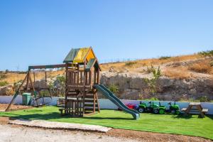 a playground with a tree house and a slide at Villa Pleiades in Karpathos