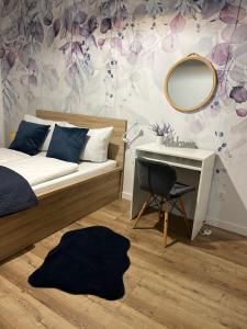 1 dormitorio con cama, espejo y escritorio en Nowy Apartament en Świnoujście