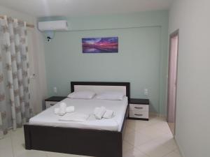 - une chambre avec un lit doté de draps blancs et d'oreillers blancs dans l'établissement Villa Alimema, à Saranda