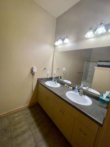 a bathroom with two sinks and a large mirror at Cannery Square Apartment 104 in Sun Prairie