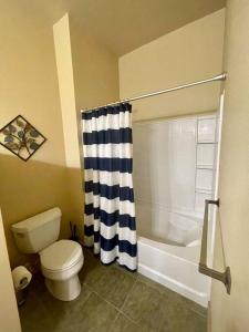 a bathroom with a toilet and a shower curtain at Cannery Square Apartment 104 in Sun Prairie